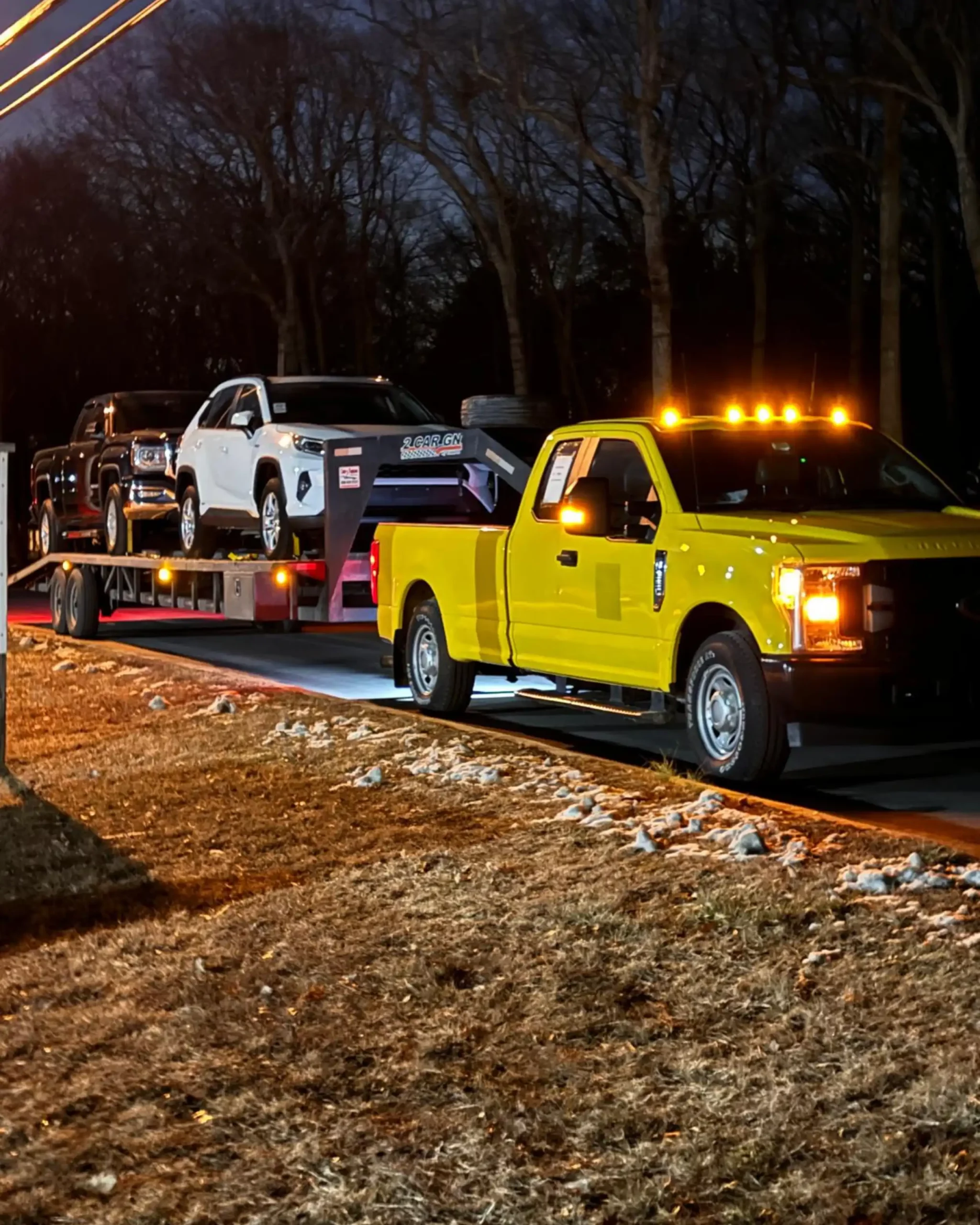 Nighttime car shipping from NJ with a Pick&Pack pickup truck hauling multiple vehicles on a trailer