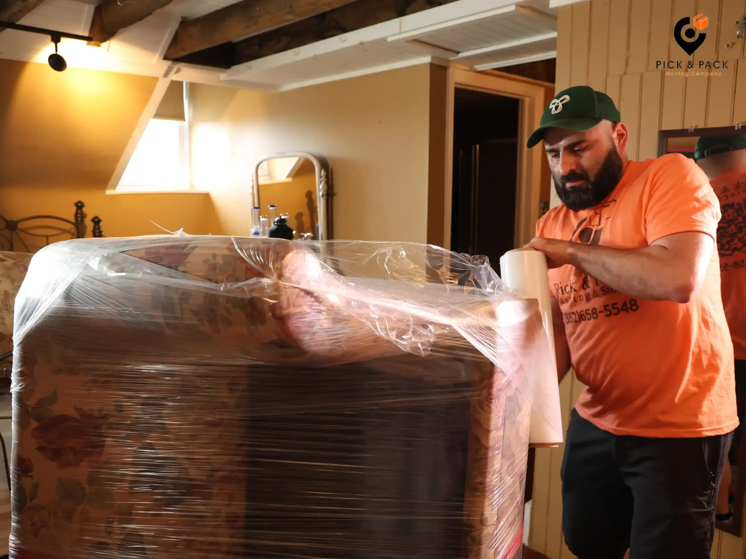 Pick and Pack Moving professional wrapping a floral armchair with plastic wrap for safe interstate relocation