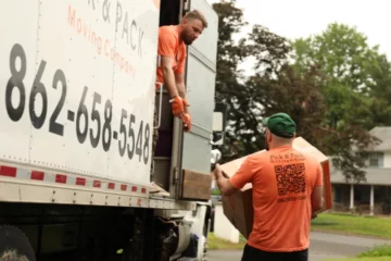 Professional movers loading boxes into a Pick and Pack Moving truck