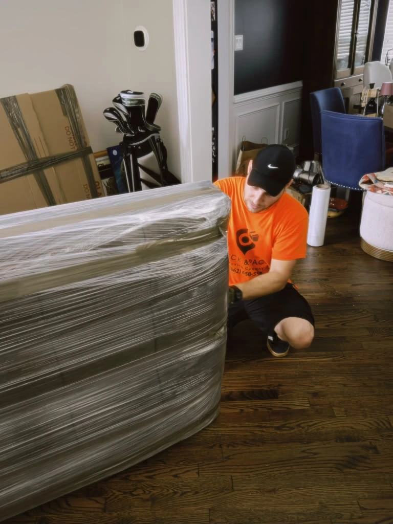 Asbury Park mover wrapping furniture in protective plastic before loading