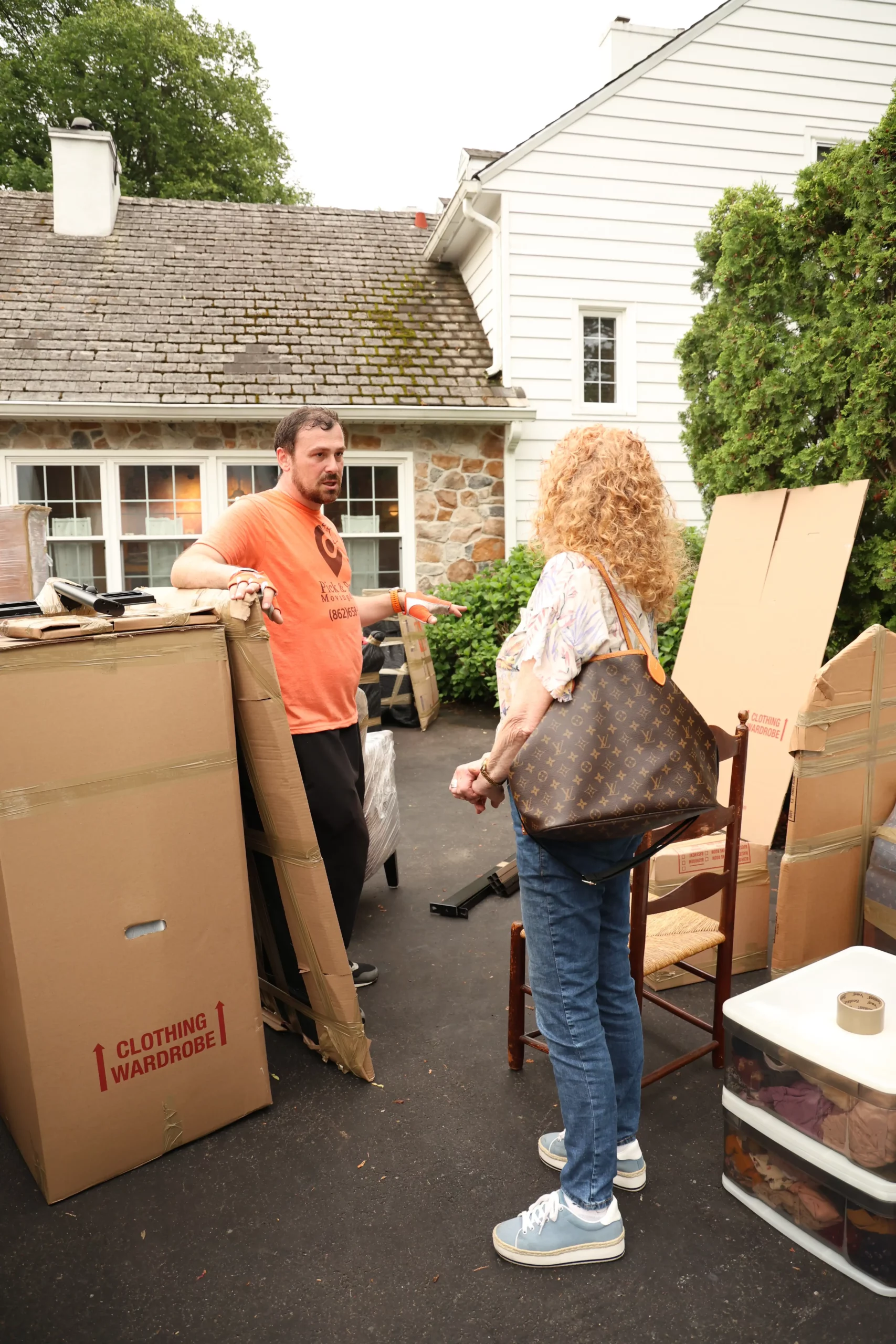 Freehold mover reviewing a packed wardrobe box with a customer during a home move