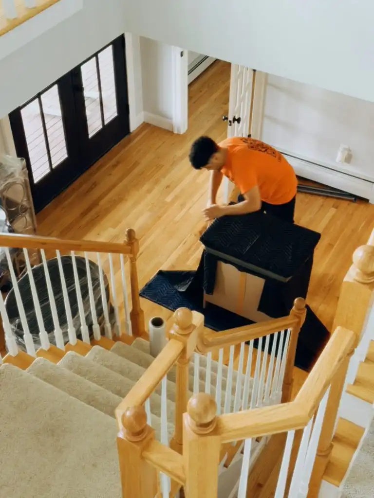 Jersey City mover carefully bringing furniture down the stairs during a home move