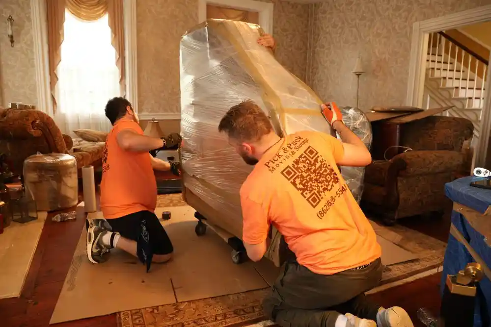 Princeton movers carefully wrapping an antique piece in a historic Mercer County home