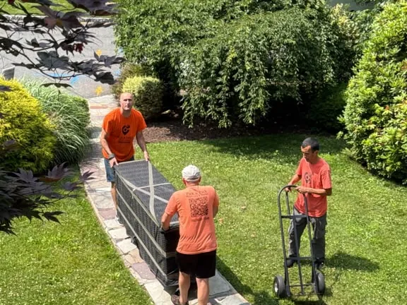 Ho-Ho-Kus movers carrying a sofa up the front path