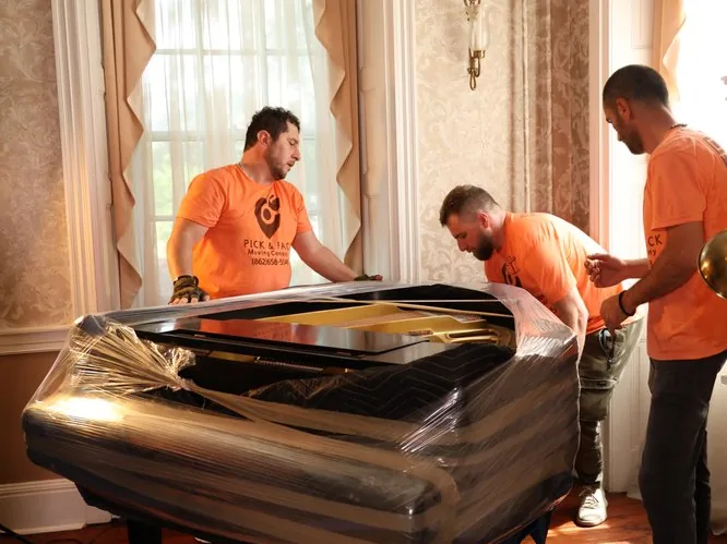 Ridgewood piano movers wrapping a grand piano