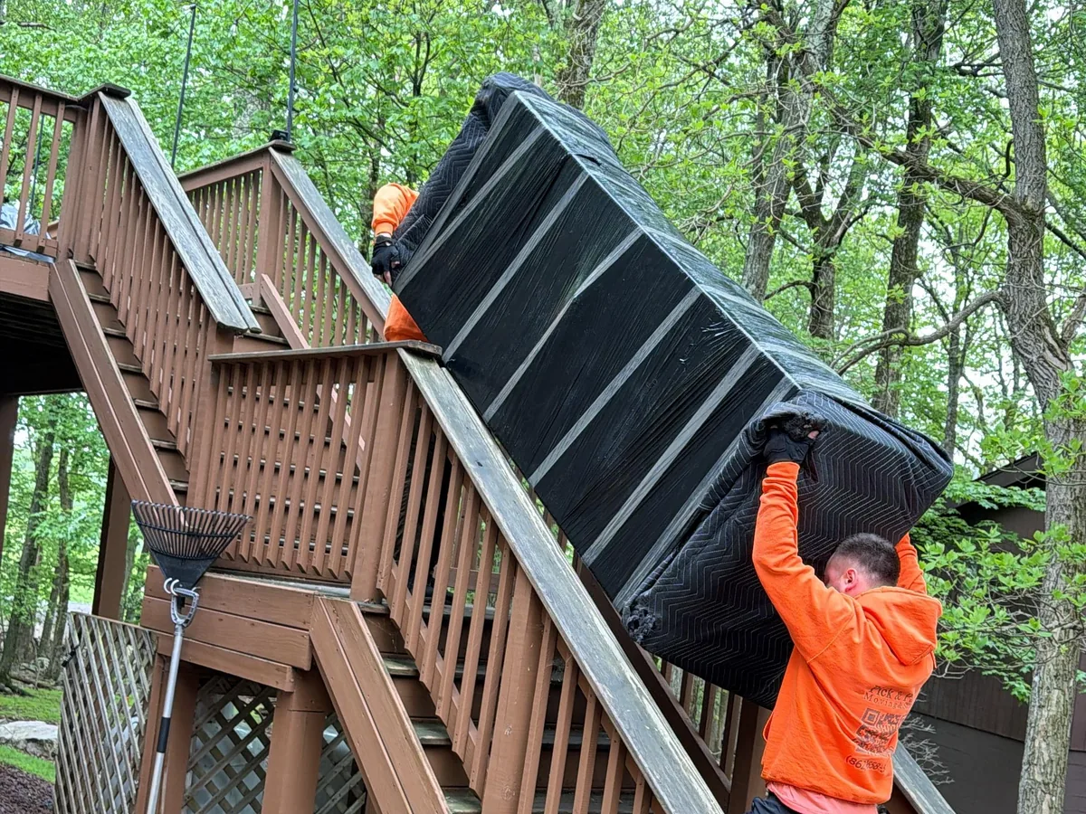 River Edge movers carrying a mattress up the stairs during a split-level move