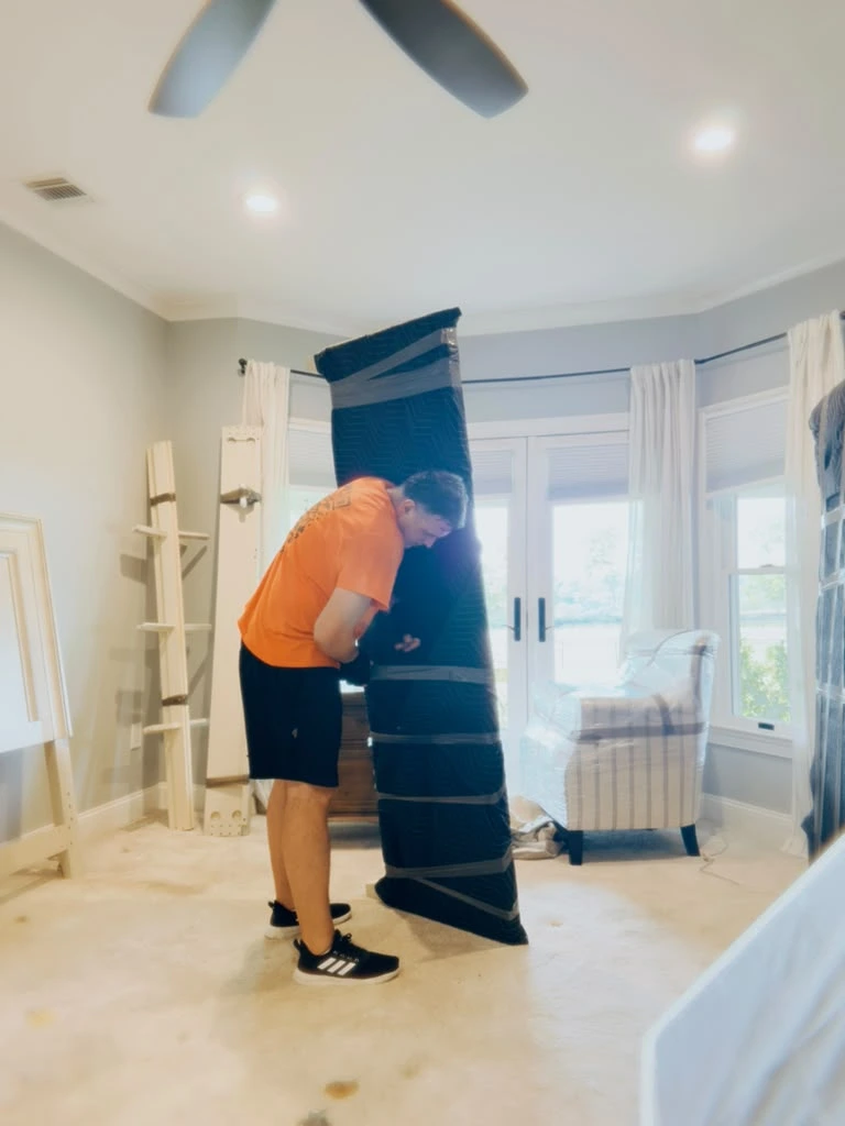 Apartment movers wrapping and protecting furniture inside a New Jersey apartment