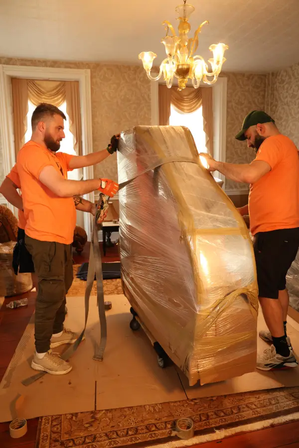 NJ piano movers from Pick and Pack carefully shrink-wrapping a piano